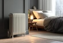 Обогреватель стоит у окна в тёплой комнате зимой